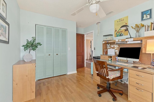 office area with light wood-style floors, visible vents, and a ceiling fan