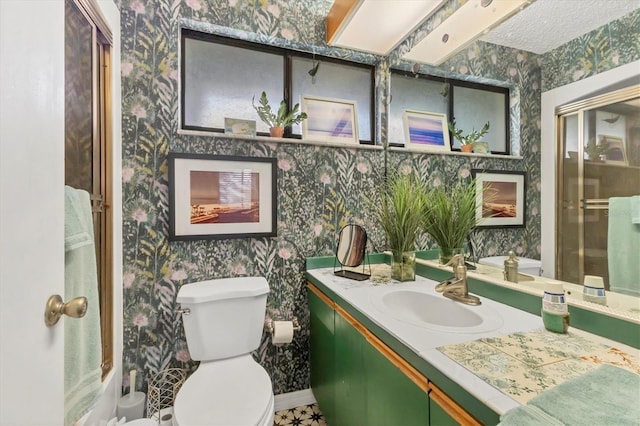 full bathroom featuring toilet, vanity, a shower with shower door, and wallpapered walls