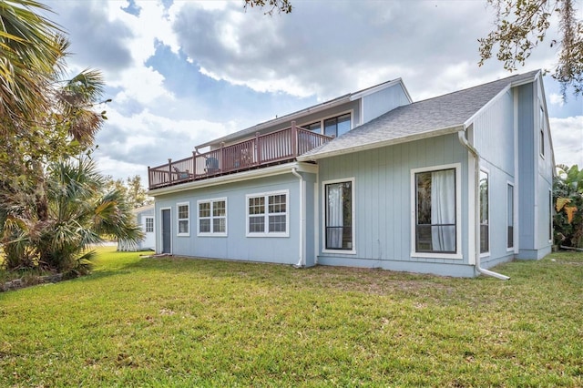 rear view of property with a yard, a shingled roof, and a balcony