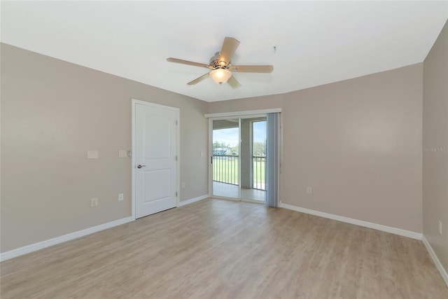 spare room with light wood finished floors, ceiling fan, and baseboards