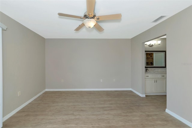 unfurnished room featuring light wood-type flooring, visible vents, ceiling fan, and baseboards