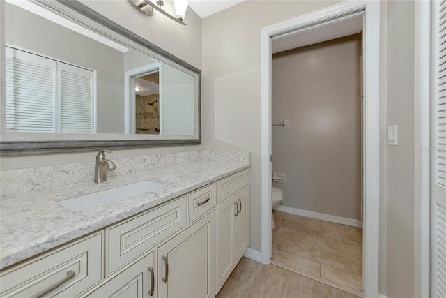 full bath featuring tile patterned flooring, toilet, vanity, baseboards, and a shower