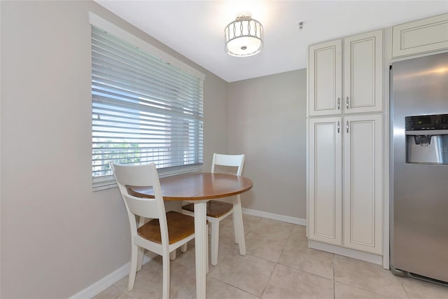 dining space featuring baseboards and light tile patterned floors