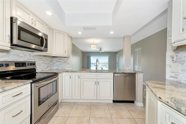 kitchen with light tile patterned flooring, a sink, visible vents, appliances with stainless steel finishes, and decorative backsplash