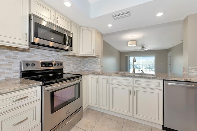 kitchen with light tile patterned flooring, a sink, visible vents, appliances with stainless steel finishes, and backsplash