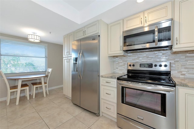 kitchen featuring light tile patterned floors, stainless steel appliances, tasteful backsplash, and cream cabinetry