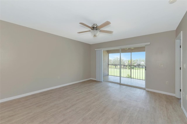 empty room featuring a ceiling fan, light wood finished floors, and baseboards