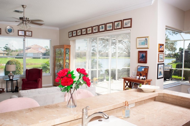 interior space with visible vents, a sink, ornamental molding, and a ceiling fan