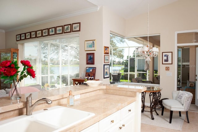 kitchen featuring a sink, white cabinetry, an inviting chandelier, and a healthy amount of sunlight