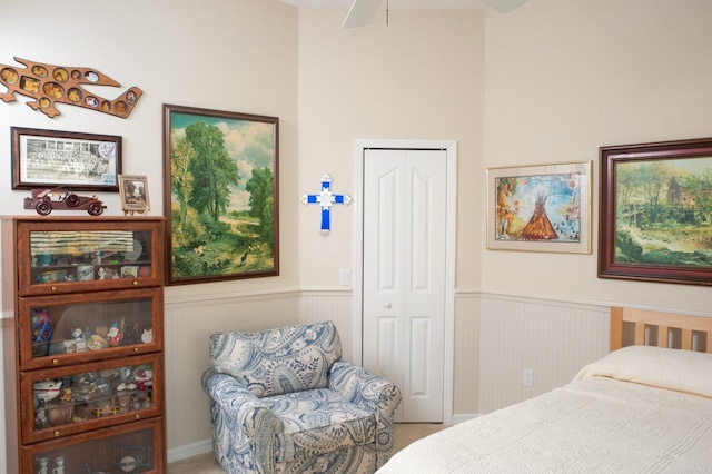 bedroom with a closet, wainscoting, and carpet floors