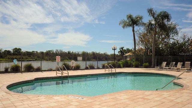 community pool with a patio and fence
