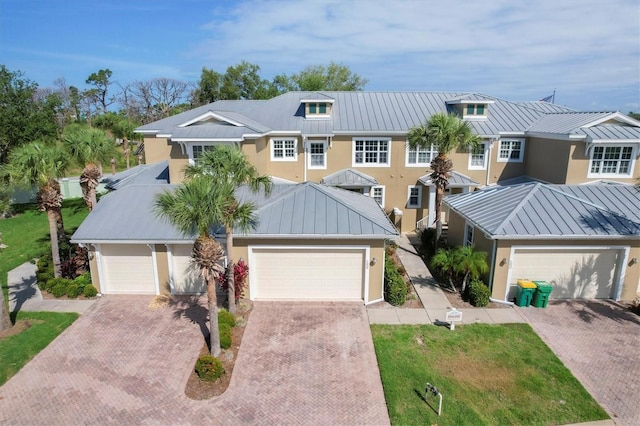 view of front of property with stucco siding, metal roof, and a standing seam roof