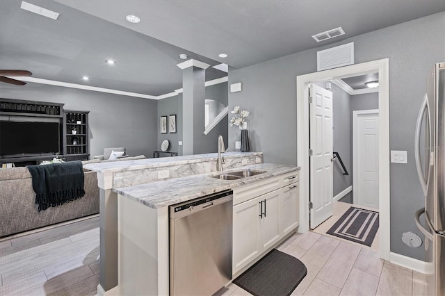 kitchen featuring visible vents, wood tiled floor, a sink, white cabinets, and appliances with stainless steel finishes