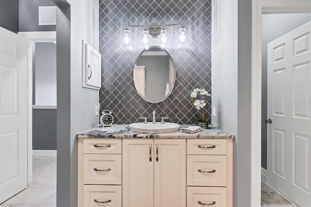 bathroom featuring visible vents, baseboards, marble finish floor, and vanity