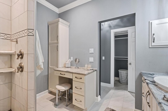 bathroom featuring baseboards, ornamental molding, vanity, and a tile shower