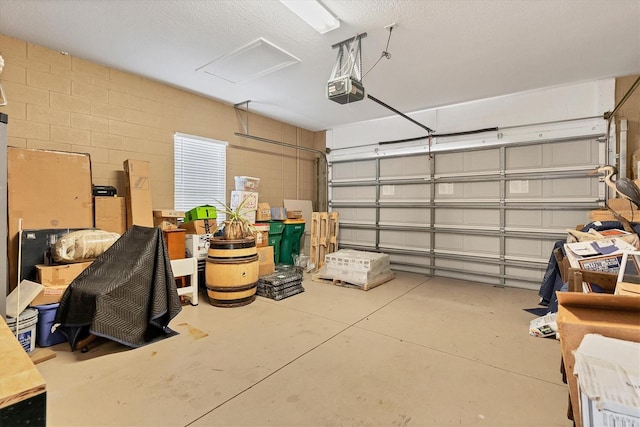 garage with a garage door opener and concrete block wall