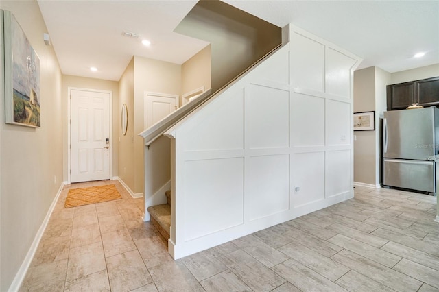 interior space with baseboards, visible vents, light wood-style flooring, freestanding refrigerator, and recessed lighting