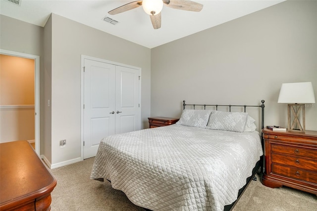 carpeted bedroom with a ceiling fan, a closet, visible vents, and baseboards