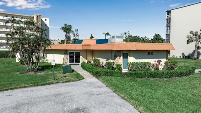 single story home featuring central AC unit, a front lawn, and stucco siding