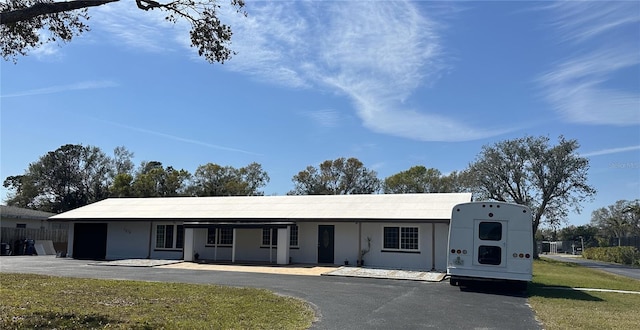 ranch-style home with a garage, driveway, a front lawn, and stucco siding