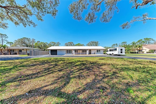 single story home with a front lawn and aphalt driveway