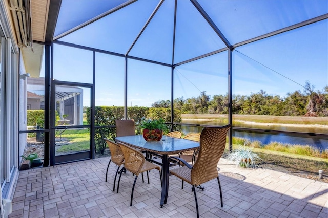 view of patio with outdoor dining space, a water view, and a lanai