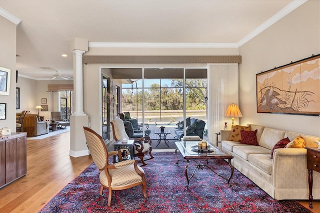 living room with crown molding, wood finished floors, and ornate columns