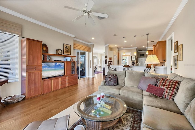 living area with ornamental molding, recessed lighting, light wood-style flooring, and a ceiling fan