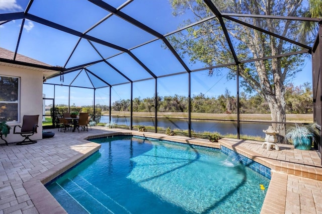 outdoor pool with glass enclosure, a patio area, and a water view