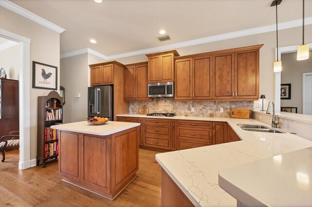 kitchen with decorative backsplash, brown cabinetry, light wood-style flooring, appliances with stainless steel finishes, and a sink