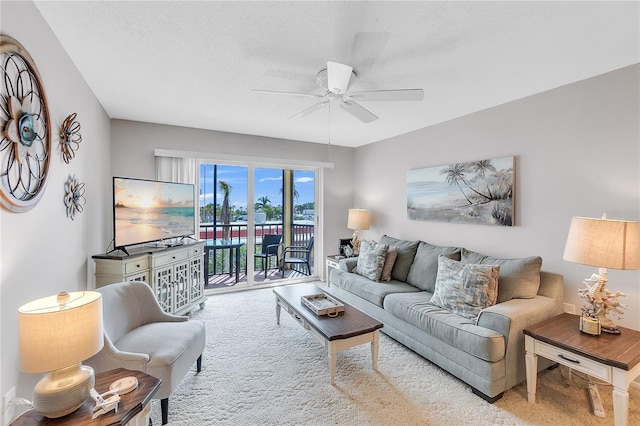 living room featuring a textured ceiling, a ceiling fan, and light colored carpet