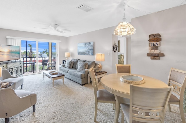 interior space featuring visible vents, ceiling fan, and light carpet