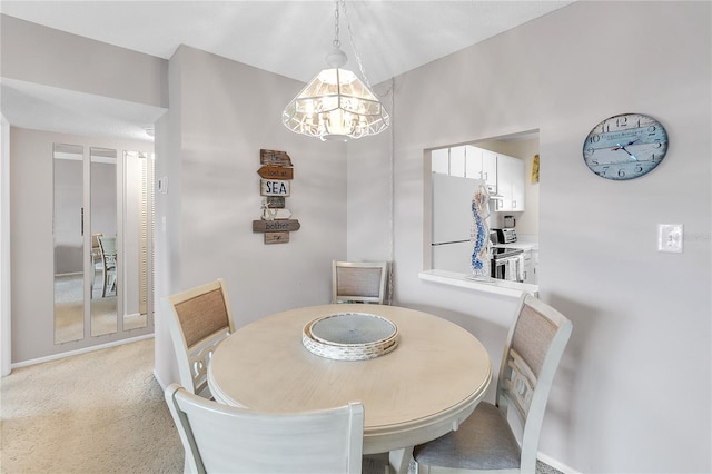 dining space featuring light carpet