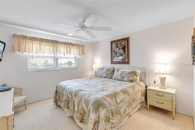 bedroom with light carpet, ceiling fan, and a textured ceiling