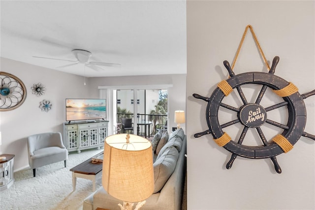 living area with a ceiling fan, carpet, and baseboards