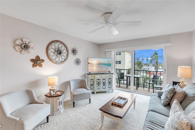 carpeted living room featuring baseboards and a ceiling fan