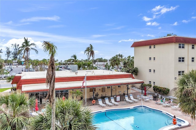 community pool with a patio and fence