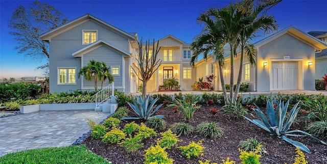 view of front facade with a garage, decorative driveway, and stucco siding