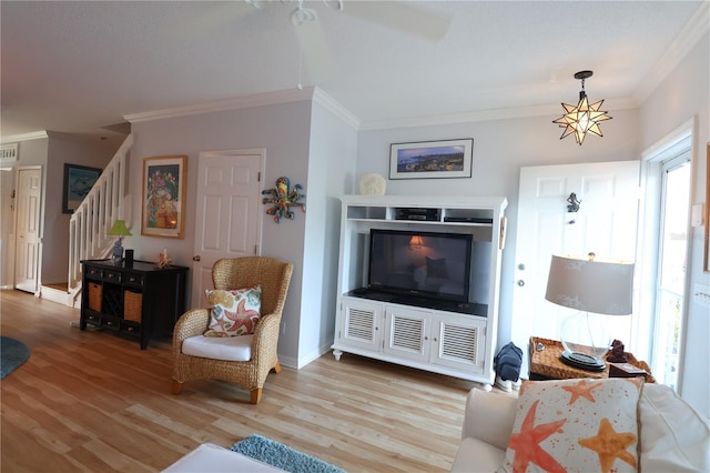 living room featuring ornamental molding, visible vents, light wood-style flooring, and stairs