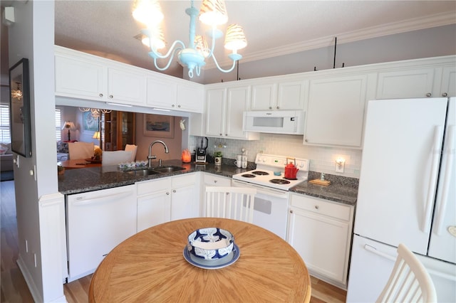 kitchen featuring a chandelier, white appliances, a sink, and white cabinetry