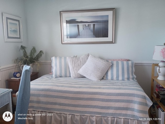 bedroom featuring a wainscoted wall