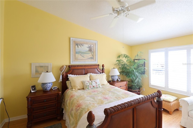 bedroom featuring lofted ceiling, wood finished floors, a ceiling fan, and baseboards