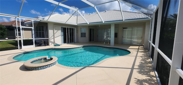 view of pool with a patio area, a lanai, and a pool with connected hot tub