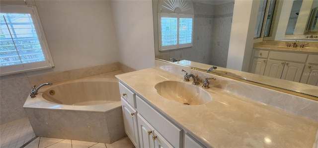 bathroom featuring two vanities, tile patterned flooring, a garden tub, and a sink