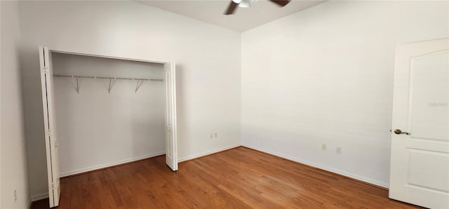 unfurnished bedroom featuring baseboards, ceiling fan, wood finished floors, vaulted ceiling, and a closet