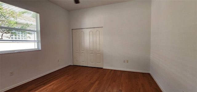 unfurnished bedroom featuring a closet, baseboards, and wood finished floors