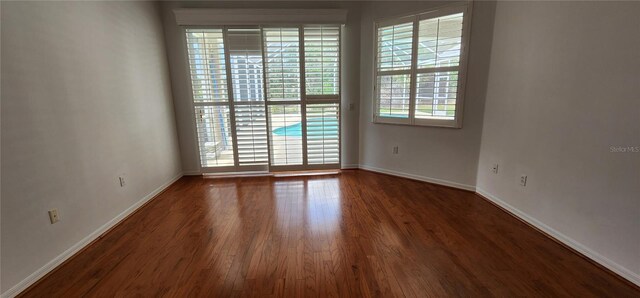 empty room with baseboards and wood finished floors