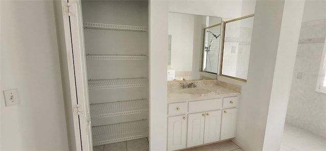 full bathroom with tile patterned flooring, a tile shower, and vanity