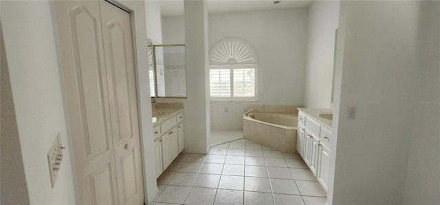 bathroom with tile patterned flooring, vanity, and a bath