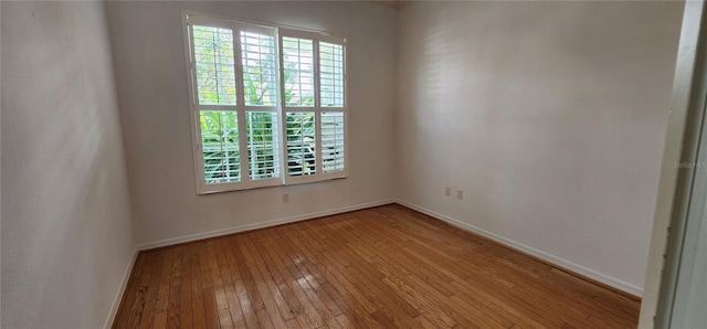 unfurnished room featuring plenty of natural light, light wood-style flooring, and baseboards